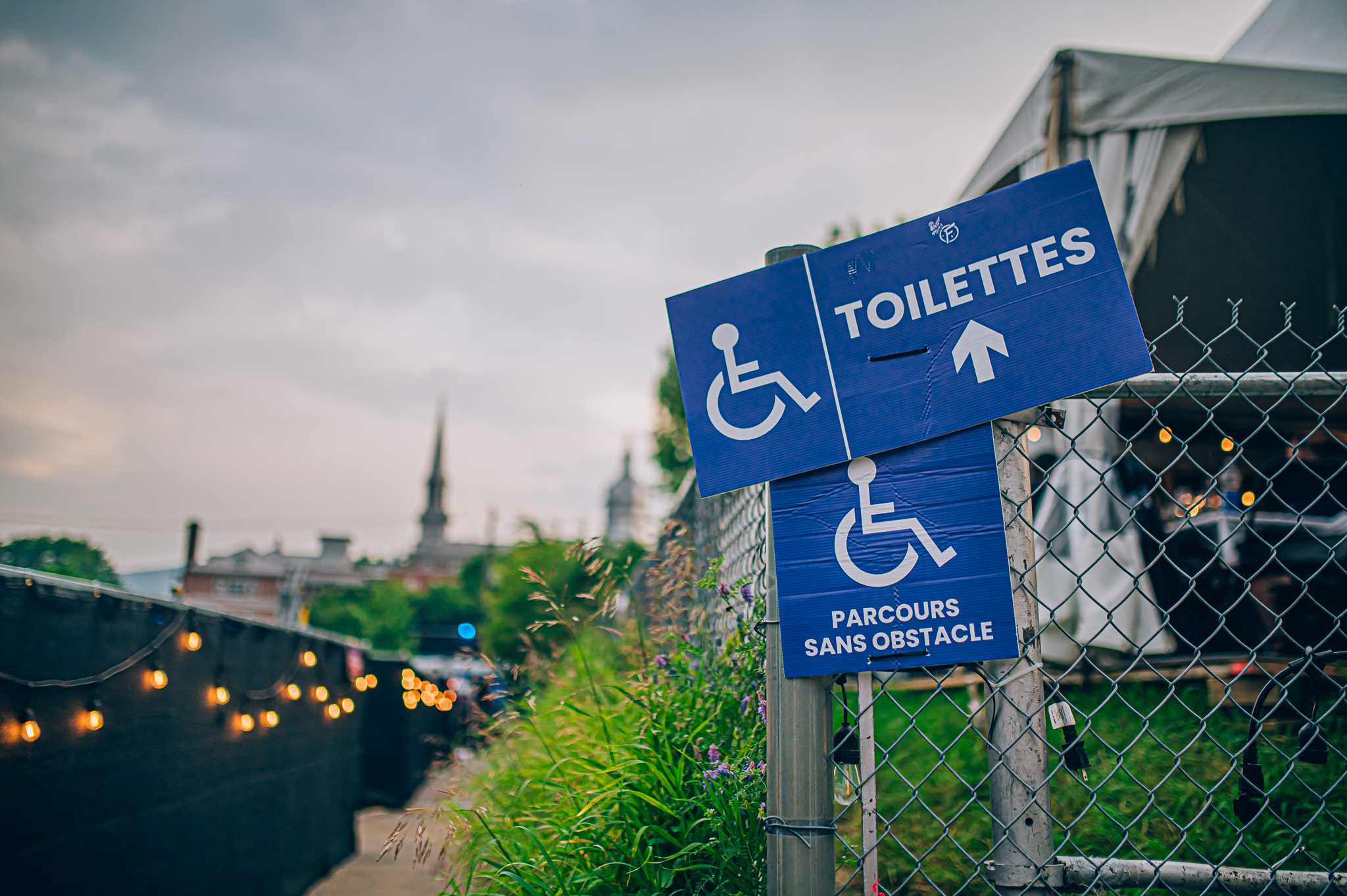 Photo d'une affiche annonçant la direction d'une toilette pour personne à mobilité réduite
